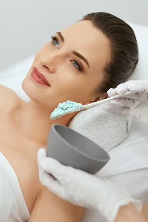 Face Skin Care. Woman Doing Alginate Facial Mask At Cosmetology Clinic. Cosmetologist Applying Mask On Skin. High Resolutionの写真素材