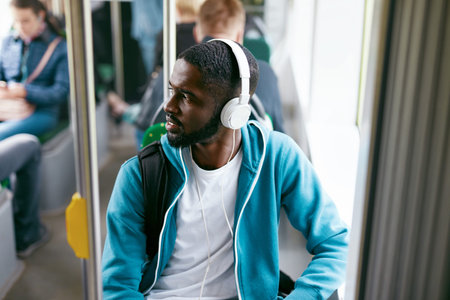 Man In Headphones Listening Music Riding In Public Transport. Handsome Black Male Traveling In Bus....