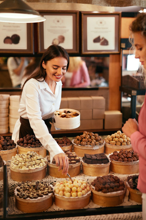 Chocolate Shop. Woman Selling Chocolate Sweets And Candies In Store. Confectionery. High Resolutionの写真素材