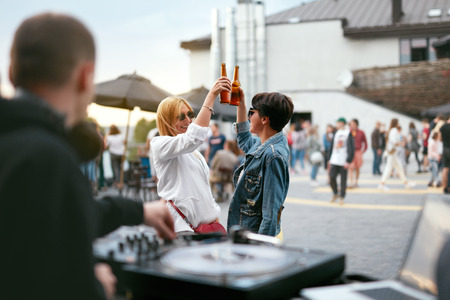 Friends On Party, Women Drinking Beer Outdoors. Girls Having Fun On Festival. High Resolutionの写真素材