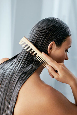 Hair Treatment. Woman With Mask On Wet Hair Closeup, Combing Hair With Wooden Hairbrush. High Resolutionの写真素材