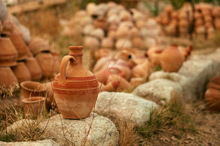 Clay Jug On Stone With Pottery Jars On Background, Heap Of Earthenware Pots. High Resolution