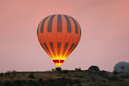 Hot Air Balloon With Fire Light At Morning Valley In Cappadocia Turkey. High Resolutionの写真素材