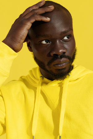 Fashion portrait of black man in yellow clothes on color background closeup. African american male...