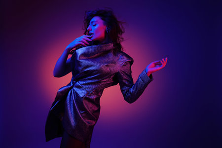 Style. High fashion girl model in stylish clothes in colorful neon lights portrait. Sexy woman in...