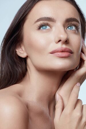 Beauty. Beautiful Woman Touching Face Close Up Portrait. Blue-Eyed Brunette Model With Perfect Skin And Natural Makeup Looking Away.の写真素材