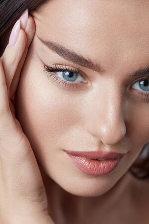 Beauty. Beautiful Woman Tightening Skin On Face Close Up Portrait. Blue-Eyed Girl With Natural Makeup And Perfect Skin.の写真素材