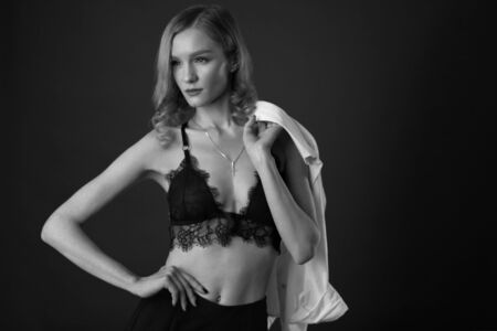 Sexy Lingerie Female Portrait. Fit Curly Woman In Fashionable Black Lace Bra And Cross. Seductive High Fashion Trend.の写真素材