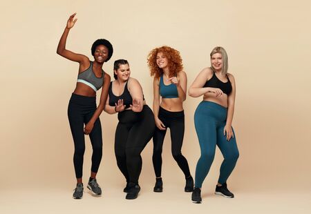 Different Race. Diversity Figure And Size Women Full-Length Portrait. Group Of Multicultural Friends In Sportswear Posing On Beige Background. Body Positive As Lifestyle.