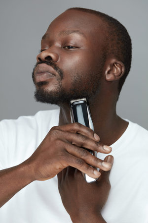 Electric Shaving. Man Removes Facial Hair. Skincare Beauty Routine. Using Of Razor Shaver Tool For...