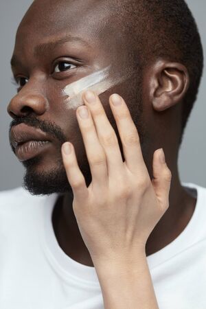 Male Makeup. Face Treatment Procedure For Man. Female Hand Applies Makeup Foundation On Man's Face. Beauty Routine.の写真素材