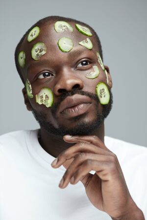 Beauty Treatment. Cucumber Mask As Skin Care. African Male Model Doing Facecare Routine. Natural Vitamin Cosmetology.の写真素材