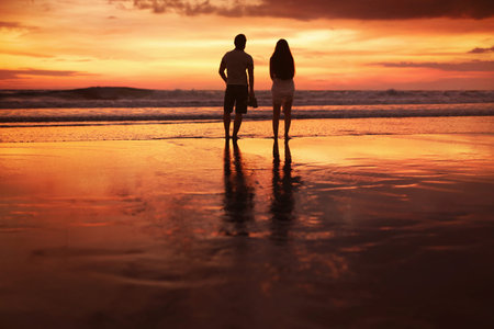 Sunset Couple. Silhouettes Of Young Man And Woman Staying Together At Beach. Vacation Or Honeymoon...