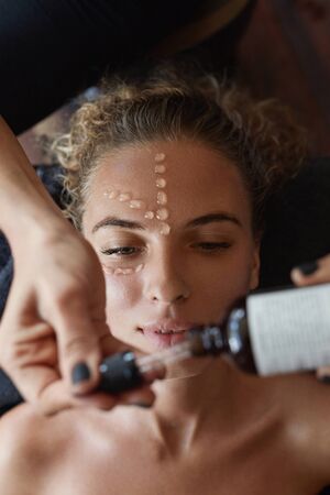 Spa Face Mask. Skin Care Beauty Treatment For Female. Beautician Applying Facial Oil Drops. Relaxed Woman On Natural Cosmetics Procedure.の写真素材