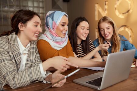 Women. Friends Meeting In Cafe. Four Smiling Girls With Laptop And Tablet Working At Bistro. Diversity Female Spending Time In Restaurant. Freelance As Lifestyle.の写真素材