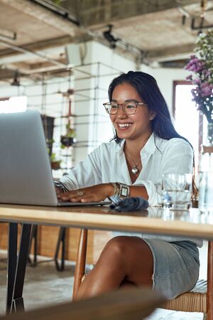 Job. Business Woman Working At Cafe. Fashion Girl In Glasses Typing On Laptop. Freelancer Having Online Meeting In Restaurant. Smiling Female At Comfortable Workplace.の写真素材
