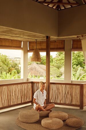 Meditation On Terrace. Relaxation And Mental Balance. Home Yoga Practicing For Healthy Lifestyle. Mature Woman Sitting On Low Seat In Lotus Pose.の写真素材