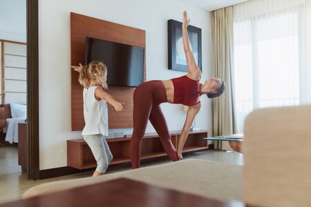 Family. Mother And Child Exercising At Home. Little Girl And Young Woman Practicing Together In Living Room. Workout Routine For Active Lifestyle.の写真素材