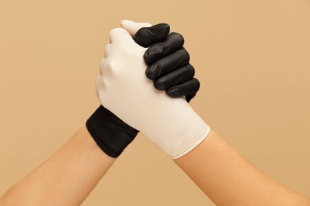 Greeting. Friends Hands In Gloves During Coronavirus Outbreak Against Beige Background. Personal Protection For Virus Prevention And Staying Healthy.の写真素材