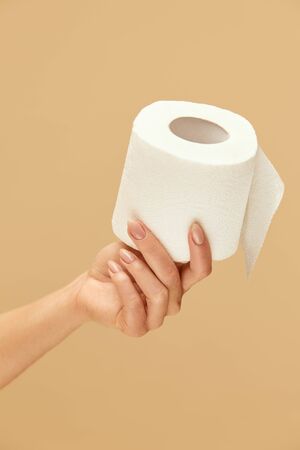 Hygiene. Toilet Paper Roll In Female Hand On Beige Background. Stop Panic About COVID Outbreak And Use High-Quality Personal Hygiene Product For Staying Healthy.の写真素材