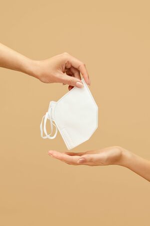 Respirator. Female Hand With Personal Protective Equipment On Beige Background. Using Breath Protection For Coronavirus And Bacterial Infection Prevention.の写真素材