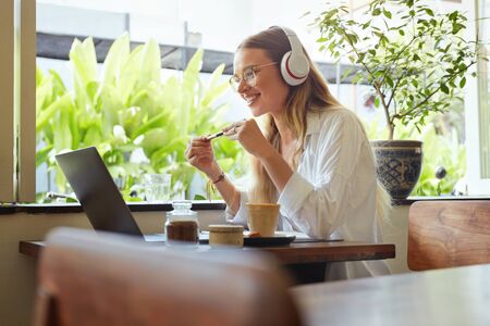 Business. Woman At Coffee Shop Having Online Meeting. Beautiful Model In Glasses Enjoying Summer Vacation And Working At Cafe. Remote Education Or Modern Creativity Job At Comfortable Workplace.の写真素材