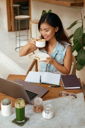 Business. Woman At Cafe Drinks Coffee. Laptop And Planner Book For Comfortable Digital Nomad Lifestyle.の写真素材