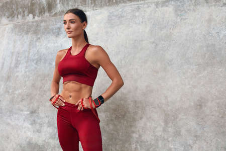 Fitness Girl. Resistance Band Exercise Outdoor For Strong Muscular Body. Fit Woman In Fashion Sporty Outfit Training Against Stone Wall. Sexy Female On Workout At Stadium.の写真素材