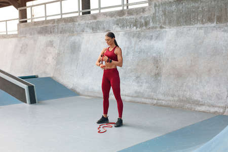 Sport. Woman Stretching On Yoga Mat Before Workout. Fitness Girl With Strong Muscular Body In Fashion Sportswear Doing Twisting Exercise At Outdoor Stadium. Urban Lifestyle And Active People.の写真素材