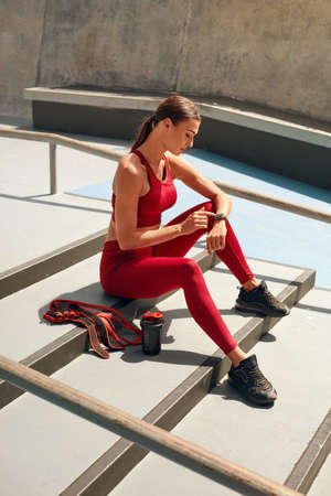 Sport. Woman Stretching On Yoga Mat Before Workout. Fitness Girl With Strong Muscular Body In Fashion Sportswear Doing Twisting Exercise At Outdoor Stadium. Urban Lifestyle And Active People.の写真素材