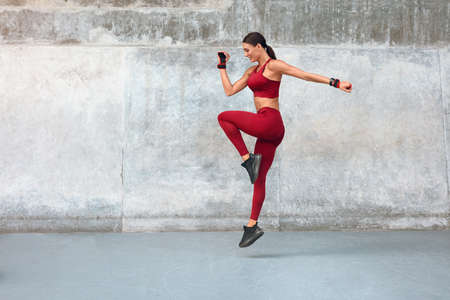 Woman. Fitness Workout With Jumping At Outdoor Stadium. Side View Of Sexy Girl With Strong Muscular Body.の写真素材