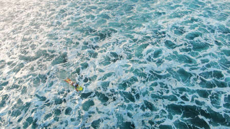 Aerial View. Surfer On Surfboard Against Blue Ocean Background. Surfing Man Floating On Board In Foam Sea. Water Sport For Active Lifestyle At Tropical Vacation.の写真素材