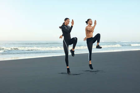 Fitness. Running On Beach As Lifestyle. Sport Couple In Fashion Sporty Outfit Working Out On Coast. Man And Woman Training Outdoor. Active Summer Vacation At Tropical Sea.の写真素材