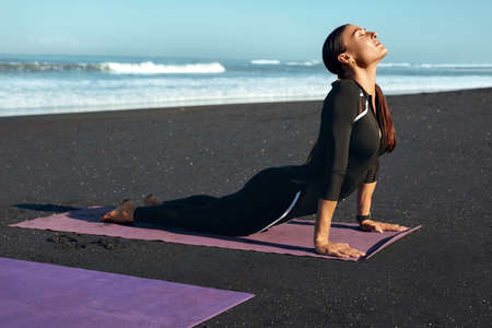 Beach. Fitness Girl Stretching On Yoga Mat. Sporty Woman With Perfect Body In Fashion Sportswear Workout Outdoor In Morning. Training On Resort At Sunrise As Part Of Active Lifestyle.の写真素材