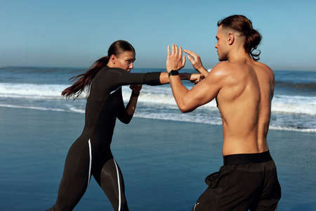 Sport. Boxing Couple On Beach Portrait. Outdoor Partner Workout On Summer Vacation As Lifestyle. Sexy Woman In Fashion Sportswear Punching Handsome Shirtless Man On Training In Morning.の写真素材