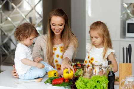 Woman With Children Cooking Healthy Food In Kitchenの写真素材