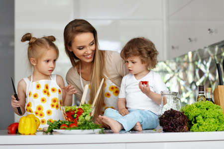 Woman With Children Cooking Healthy Food In Kitchenの写真素材