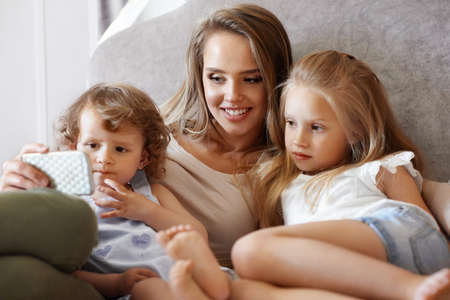 Mother And Children Using Phone At Home.の写真素材