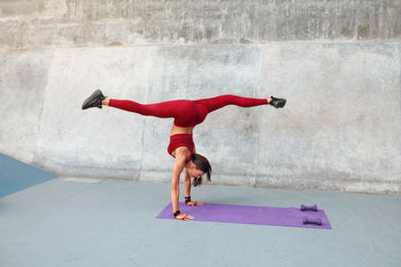 Workout. Fitness Girl Standing On Hands. Fit Woman In Fashion Sporty Outfit Doing Split Twine In Air. Sexy Female Stretching On Yoga Mat Outdoor. Flexibility Exercises For Strong Muscular Body.の写真素材