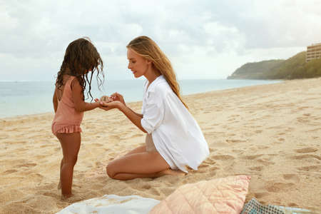 Summer. Family Picnic On Beach. Portrait Of Young Woman With Son Enjoying Lunch At Tropical Ocean. Mother And Handsome Boy On Vacation Near Sea. Organic Fruit And Natural Vitamins.の写真素材