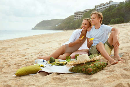 Summer. Family Picnic On Beach. Portrait Of Young Woman With Son Enjoying Lunch At Tropical Ocean. Mother And Handsome Boy On Vacation Near Sea. Organic Fruit And Natural Vitamins.の写真素材