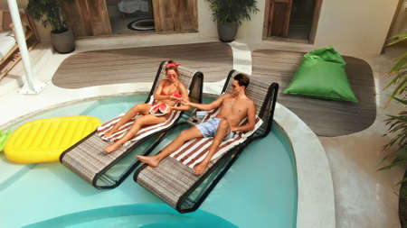 Top View Of Couple At Pool. Happy Man And Woman Enjoying Summer Vacation Or Honeymoon At Tropical Villa. Romantic Summertime On Poolside At Luxury Resort. Fashion Male And Female In Love.の写真素材