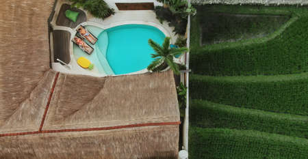 Summer. Top View Of Couple At Pool. Happy Man And Woman Enjoying Summertime At Tropical Villa With Straw Roof. Fashion Male And Female On Romantic Vacation Or Honeymoon At Poolside.の写真素材