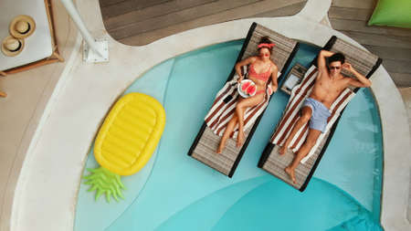 Top View Of Couple At Pool. Happy Man And Woman Enjoying Summer Vacation Or Honeymoon At Tropical Villa. Romantic Summertime On Poolside At Luxury Resort. Fashion Male And Female In Love.の写真素材