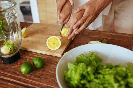 Romantic Couple At Kitchen. Woman Cutting Fresh Organic Lemon And Man Carrying Her Hands. Healthy Diet, Natural Vitamins For Vegetarian Nutrition. Preparing Detox Cocktail Or Smoothie Kitchen.の写真素材