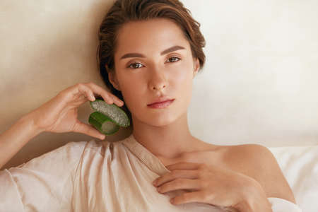 Beauty Portrait Of Woman With Aloe Vera Slices. Beautiful Model With Perfect Glowing And Hydrated Skin. Tender Brunette With Natural Makeup Looking At Camera. Organic Cosmetic For SPA Therapy.の写真素材