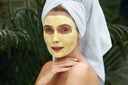 SPA. Woman With Clay Mask On Face Close Up Portrait. Young Model Touching Naked Shoulder And Enjoying Perfect Skin After Treatment. Relaxed Female Having Beauty Procedure At Tropical Resort.の写真素材