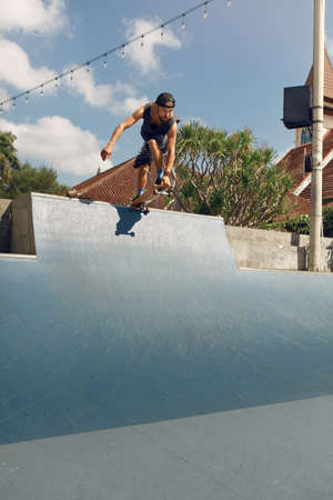 Skater Man Skateboarding On Concrete Ramp At Skatepark. Handsome Guy In Casual Outfit Riding On Skateboard Outdoor. Urban Subculture And Extreme Sport As Lifestyle In City.の写真素材