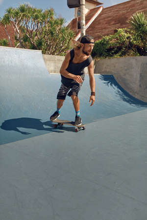 Skateboarding. Man In Urban Outfit Riding On Skateboard On Concrete Ramp At Skatepark. City Sport As Hobby For Active Guys. Skater Subculture And Summer Activity As Lifestyle.の写真素材