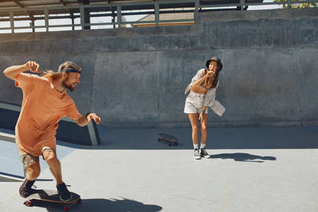 Skaters. Girl And Guy At Skatepark. Portrait Of Hipster Friends In Casual Outfit Riding On Skateboard Outdoors. Urban Subculture Style And Summer Extreme Sport In City. Skateboarding For Active Lifestyle.の写真素材